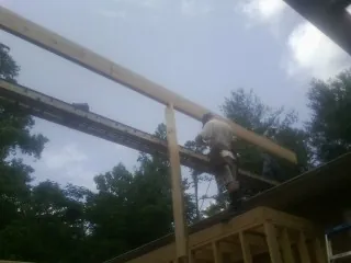 Carpenter setting a ridge beam over a new addition frame — Ice Dam Removal by Roofing Brothers in Awendaw