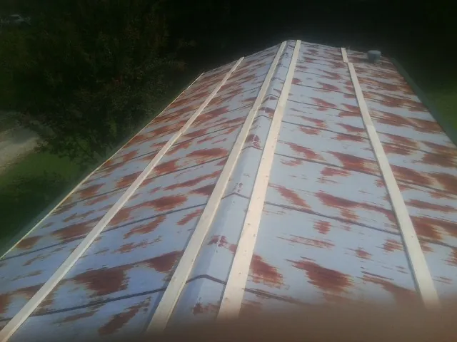 Rusted metal roof panels with new wood purlins before replacement — Storm Damage Roof Repair in Awendaw by Roofing Brothers