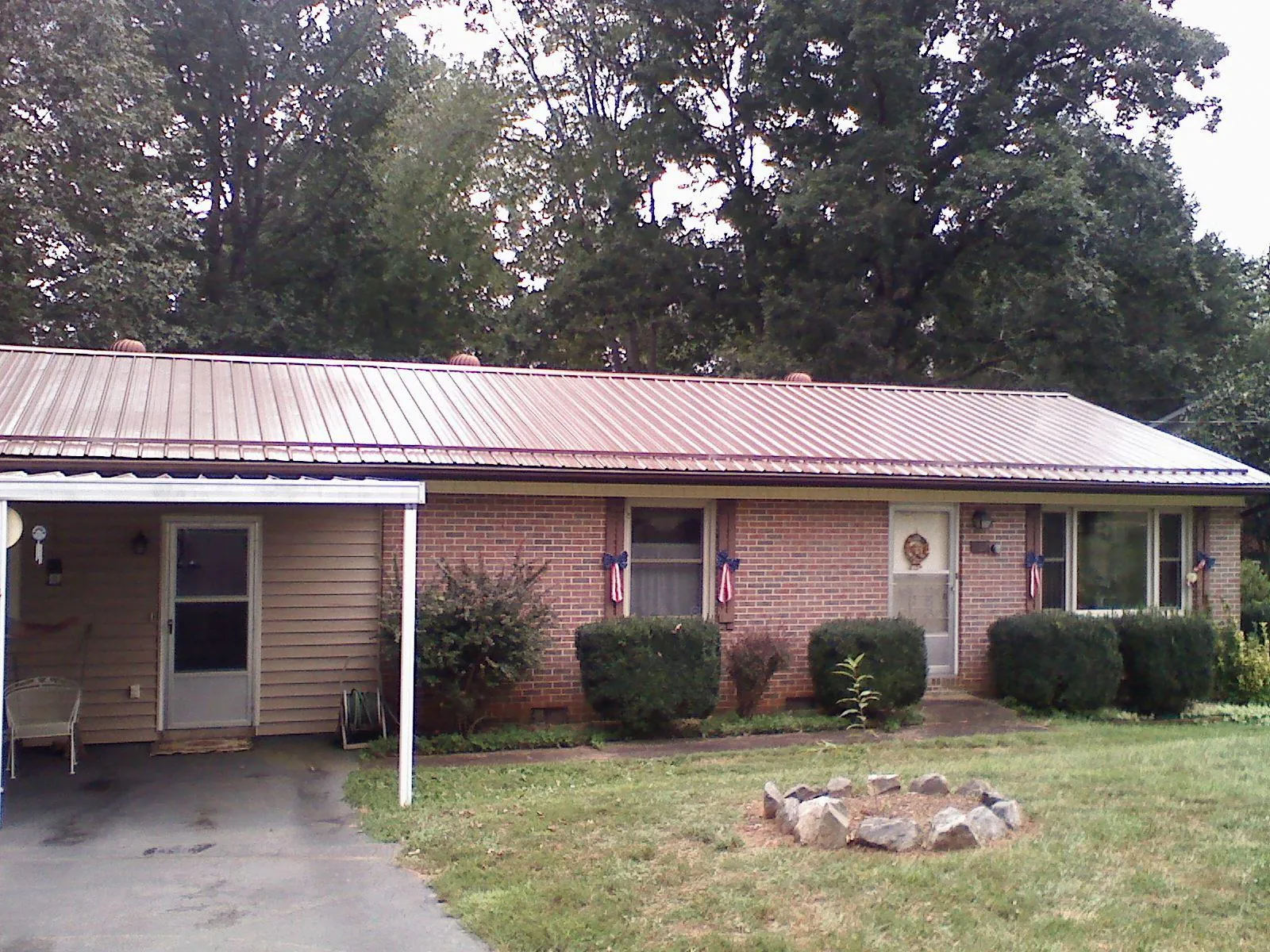 Bronze metal roof and carport on a brick ranch home — Roof Repair work by our crew in Awendaw