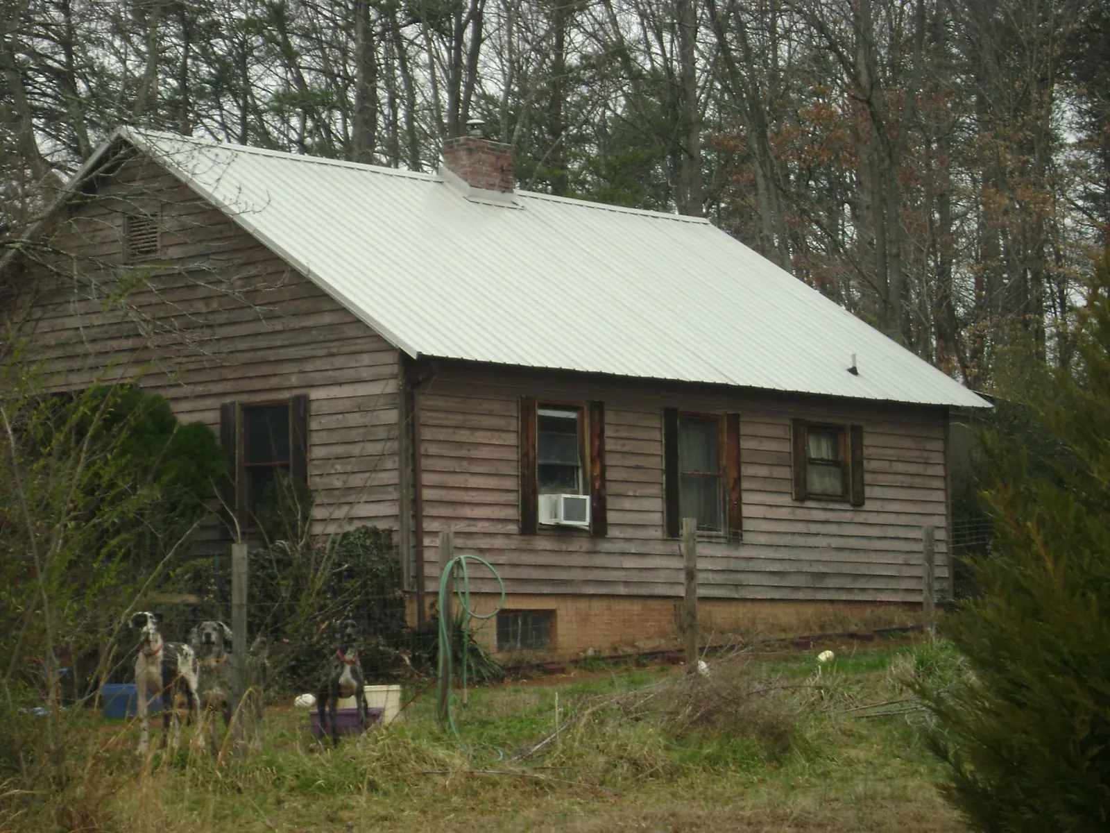 White metal roof on an old wood sided farmhouse, from a Metal Roof Installation job in Awendaw